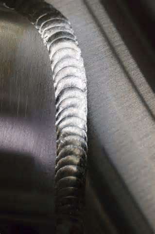 Close-up of a clean TIG weld bead running along brushed steel